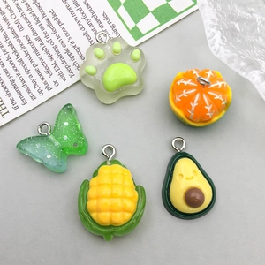 Flat lay of colorful resin fruit and shape charms with metal rings for DIY jewelry