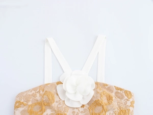 Detailansicht der weißen 3D-Blumenverzierung auf dem Jacquard-Crop-Top mit Trägern