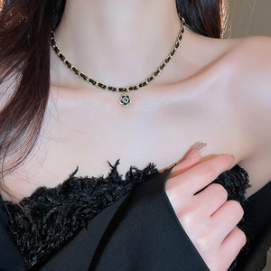Detail of camellia pendant with crystals on gold-plated leather interwoven chain