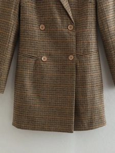 Détail d'un blazer croisé marron à carreaux avec texture classique en pied-de-poule