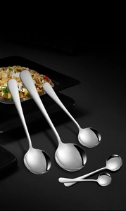Polished stainless steel round spoon set in various sizes on a dark background