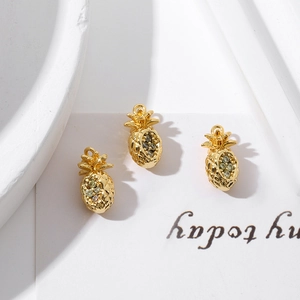 Close-up of three 18K gold plated pineapple pendants with sparkling zircon stones