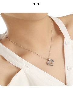 Close-up of S925 sterling silver hollow heart pendant necklace worn on a female neck