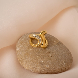Macro view of 18k gold plated titanium ring with pavé zircons on a smooth pebble