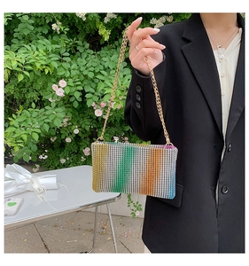 Detailed macro view of rainbow rhinestone shoulder bag with fine gold chain and gradient decor
