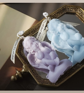 Detailed view of blue and purple angel scented candles on a vintage golden mirror tray