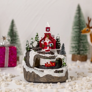 Close-up of resin Christmas snow house featuring Santa Claus and a miniature train