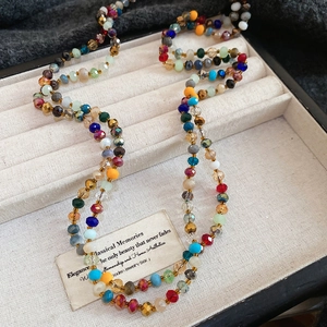 Macro view of multi-color faceted crystal beads on a Bohemian style long necklace