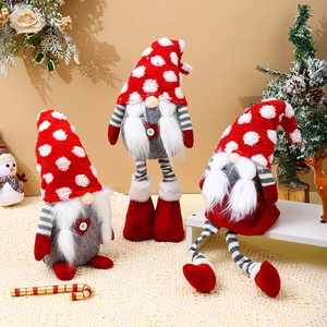 Three assorted Christmas gnomes with knit hats and long legs on a festive tabletop