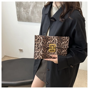 Detail of leopard print clutch featuring a gold metal lock and faux fur texture