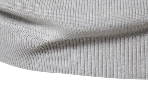 Macro shot of grey fine-knit ribbed texture on the cuff and hem of a men's sweater