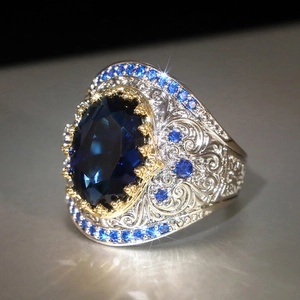 Dettaglio anello bohémien in argento con grande gemma blu e castoni in oro dorato