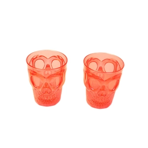 Glow-in-the-dark red skull shot glasses for Halloween parties and bars on white background