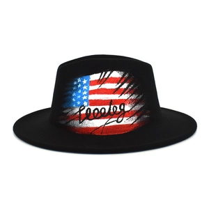 Detail of black fedora hat featuring artistic American flag print and graffiti lettering
