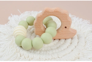 Detail of baby teething bracelet with light green silicone beads and a beech hedgehog toy