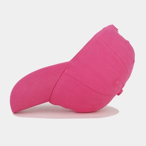 Detail view of pink cotton baseball cap with N embroidery and curved brim on white background