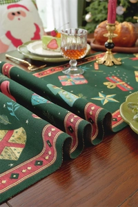 Detail of green jacquard Christmas table runner with festive gift and star patterns