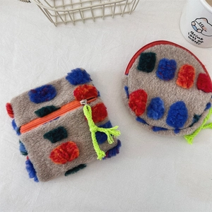 Detail view of colorful plush mini bag set with dots and neon green zip pulls