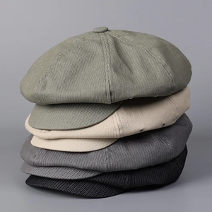 Detail of vintage corduroy newsboy caps in four colors showing textured fabric and buttons