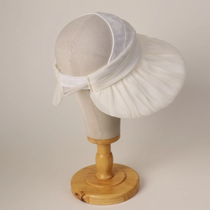 Detail of white mesh sun hat featuring elegant pleated brim and elastic back strap