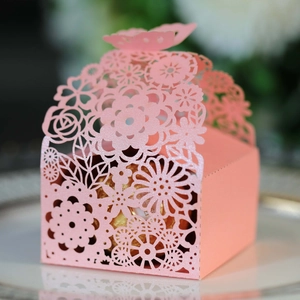 Close-up of pink laser-cut favor box with pearlescent finish and chocolate inside