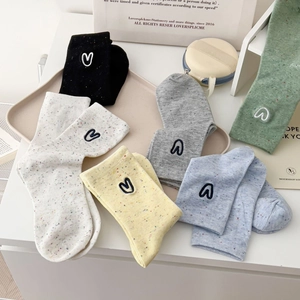 Detailed view of colorful confetti knit socks with heart embroidery in six various colors