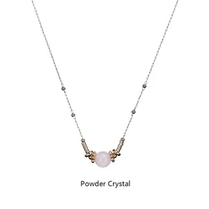 Macro detail of powder crystal pendant with golden beads on a stainless steel chain
