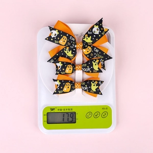 Three-piece Halloween bow hair clips weighing 17.9 grams on a precision digital scale