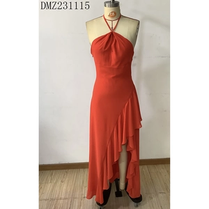 Detail of red halter dress featuring ruffled irregular hemline and sleek chiffon fabric