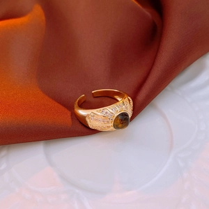 Macro shot of vintage gold-plated ring with brown tiger eye stone and zircon accents