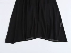 Détail de l'ourlet de la robe en mousseline noire montrant la texture plissée