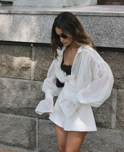 Detail of white lantern sleeve chiffon blouse with delicate texture and pleated cuff detail