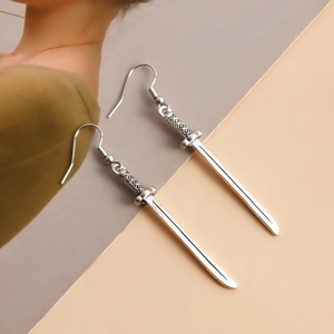 Vue détaillée des boucles d'oreilles sabre samouraï argentées avec texture métallique