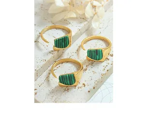 Détail de bagues ajustables plaquées or avec incrustations de malachite verte
