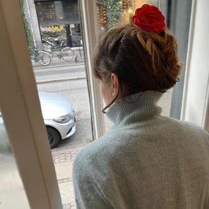 French style red fabric rose hair claw clip worn on a bun hairstyle shown from the back