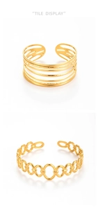 Detail view of gold snake-pattern layered and chain link open cuffs in polished steel