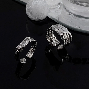 Irregular silver molten lava texture open ring set on a sleek black reflective surface
