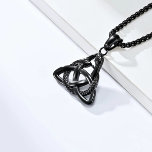 Macro shot of black stainless steel Celtic Triquetra knot and twin snake pendant details