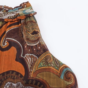 Detailed macro view of bohemian paisley chiffon fabric with gold metallic thread details