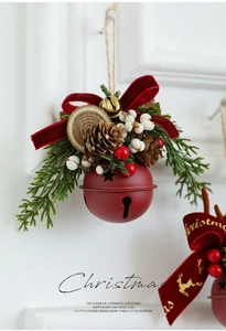Detail of red Christmas bell ornament with pine cones berries and velvet ribbon bow