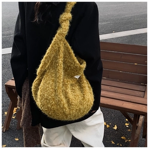 Detail of knot shoulder strap and fuzzy wool-like texture on mustard yellow tote bag