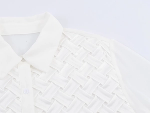 Détail d'un chemisier blanc en satin avec col à revers et texture tissée élégante devant