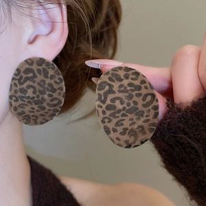 Macro shot of large oval leopard print earrings with vintage flocking texture