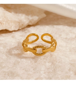 Close-up of golden chain link adjustable ring on natural stone and silk background