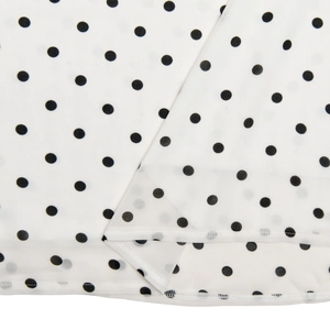Macro view of white polka dot chiffon fabric showing fine rolled hem stitching detail