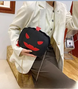 Detail of Jack-o'-lantern pumpkin bag with red leather patches and gold chain strap