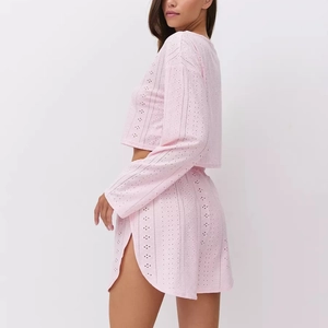 Dettaglio del tessuto ricamato rosa sul set con top a maniche lunghe e pantaloncini
