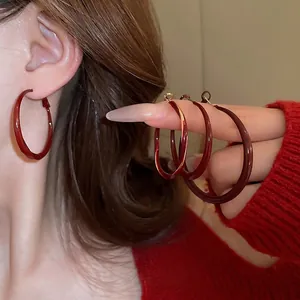 Minimalist deep wine red hoop earrings in glossy resin finish with twisted C-shape design