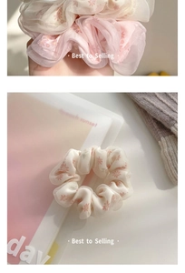 Close-up of oversized floral mesh scrunchies with delicate red flower patterns
