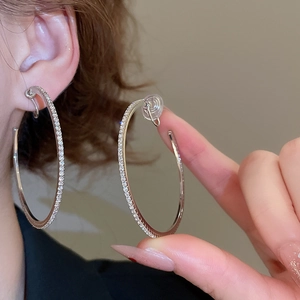 Close-up of sparkling silver hoop earrings with pavé diamond crystals for women